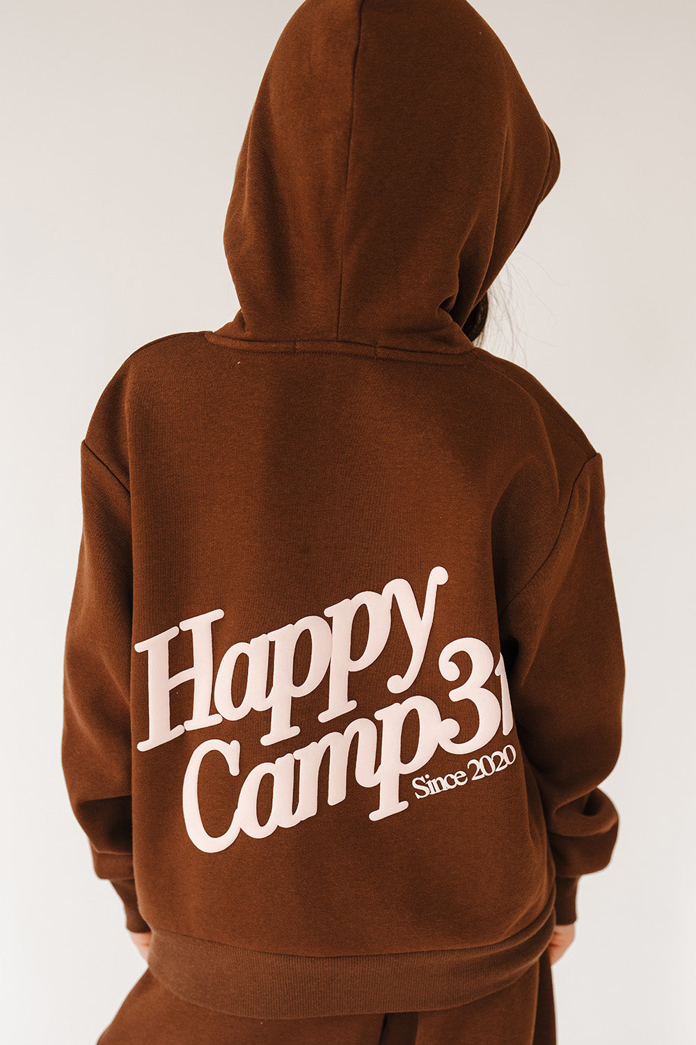 Back of the espresso Puff Series Core Youth Hoodie with large pink Happy Camp3r logo. The Happy Camp3r