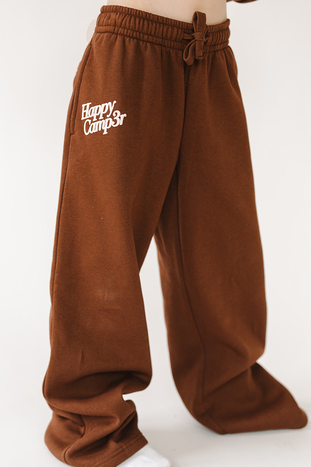 Fawn Love Youth Sweatpants in brown with cream Happy Camp3r logo, front view. The Happy Camp3r