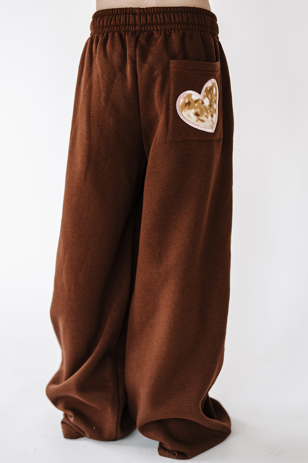 Back of the brown Fawn Love Youth Sweatpants with fawn print heart patch. The Happy Camp3r