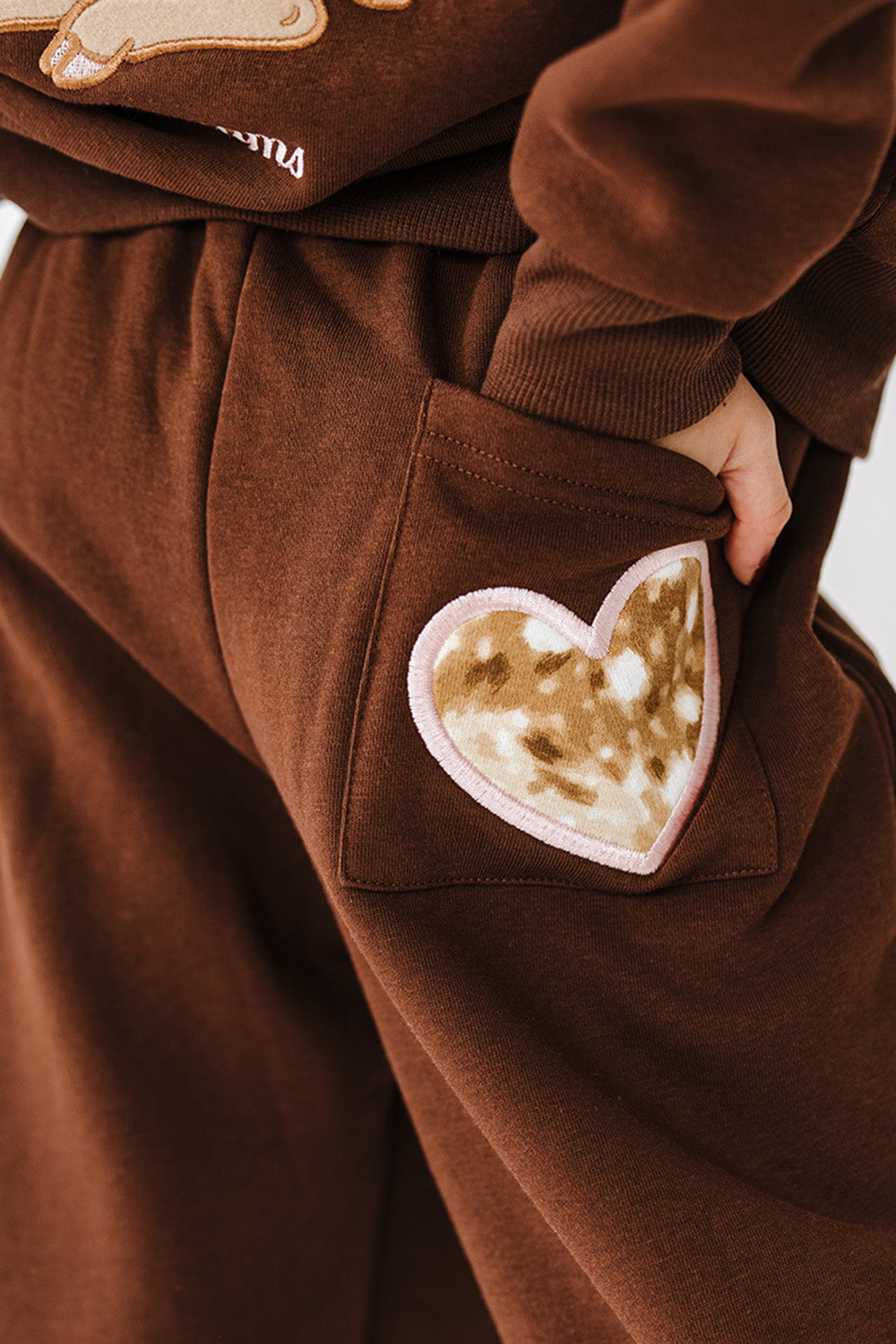 Close up of the fawn print heart pocket patch on the Fawn Love Youth Sweatpants. The Happy Camp3r
