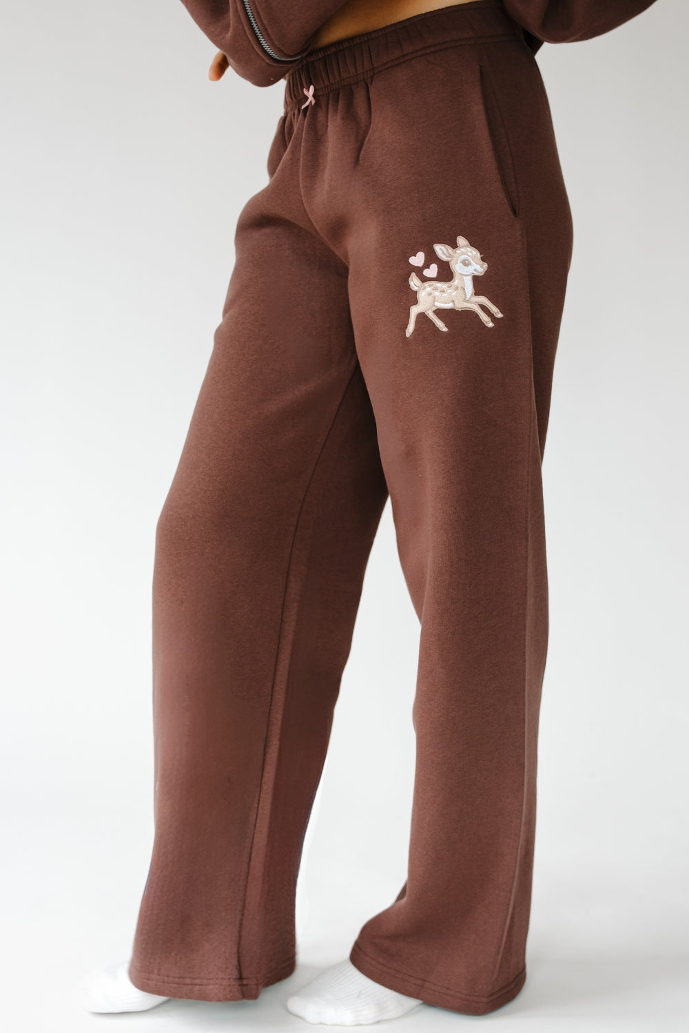 Brown Fawn Love Sweatpants with cream fawn graphic on the leg, front view. The Happy Camp3r