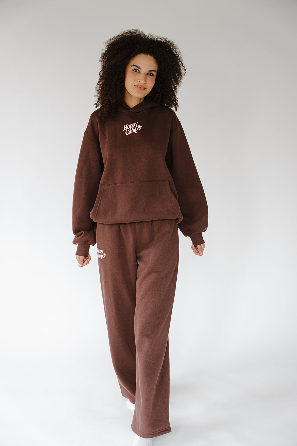 Model in the espresso Puff Series Hoodie and matching sweatpants, full length. The Happy Camp3r