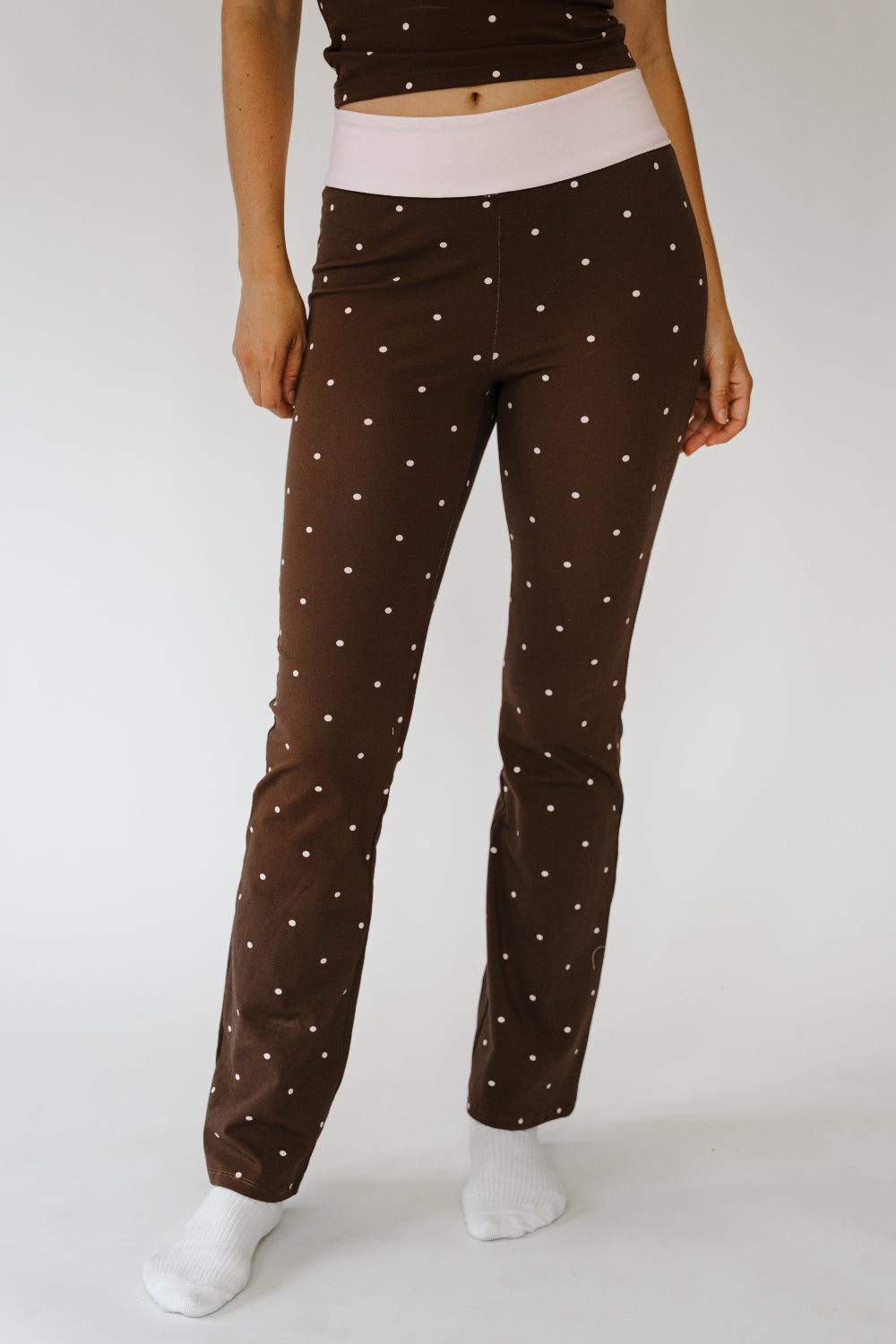 Cocoa Dot Peyton Bottoms, brown polka dot flare pants with pink foldover waistband, front view. The Happy Camp3r